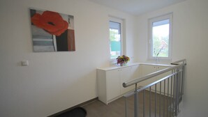 A clean, modern room with white walls, a large window, and a metal railing. - 1010 - Seesternweg - OG - 1010 / Seesternweg in Dahme (Dahme)