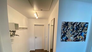A narrow hallway with a wooden floor, a white door, and a framed picture on the wall. - 1012 - Holiday apartment Strandburg - 1012 Holiday apartment Strandburg (Dahme)