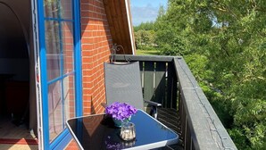 A balcony with a table, chairs, and a flower vase. - 7016 "incl. beach chair" - 7016 "incl. beach chair" - An der Aue 9c - Apartment 25 (Dahme)