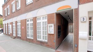 A brick building with large windows and a sign above the entrance. - Sandwall 2, Whg. 4 - Apartment at Sandwall for 2 persons on approx. 44 m² (Wyk auf Föhr)