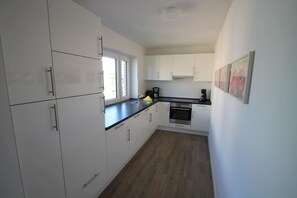 Een koelkast, een oven, een kookplaat, een vaatwasser