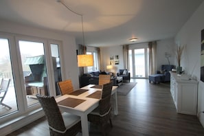 Amplia sala de estar con mesa de comedor, sofás y zona de cocina.