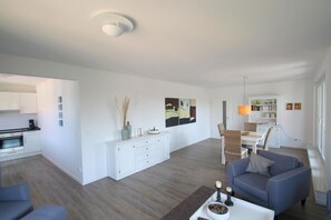 A modern living room with a sofa, coffee table, and a dining area with chairs and a table. - 1908 - Am Kurpark - 1908 - Apartment on the 2nd floor "Am Kurpark" (Dahme)
