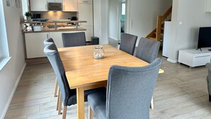 A modern kitchen with white cabinets, a wooden countertop, and a hanging light fixture. - 1310 - House Greta - House Greta in Dahme 1310 (Dahme)