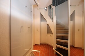 Ein Flur mit Treppe, einer Tür und einem Heizkörper.