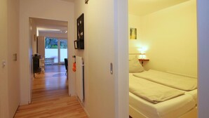 A hotel room with a bed, a bedside lamp, and a view of the outside. - Fasanenweg 2 b, Whg. 2 - vacation apartment in Wyk with 3 rooms, approx. 58 m² on the ground floor with (Wyk auf Föhr)