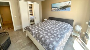 A bedroom with a bed, a wardrobe, a painting, and a decorative shell.