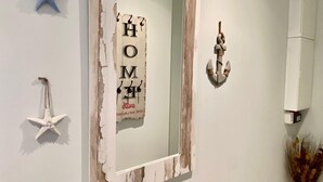 A room with a mirror, starfish decorations, and a sign that reads "HOME".