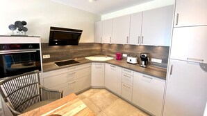 A modern kitchen with a built-in oven, microwave, and a coffee maker.