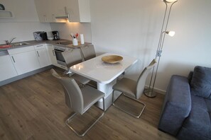 Uma cozinha moderna com uma mesa de jantar, cadeiras e um sofá.