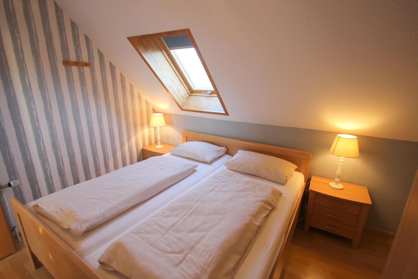 A twin room with two beds, a skylight, and bedside lamps.