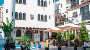 Un patio con piscina, plantas en macetas y mobiliario para exterior.