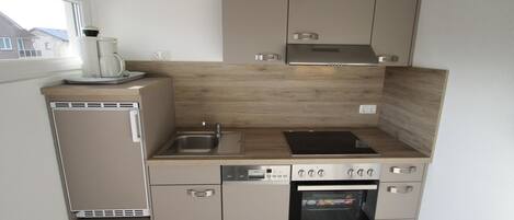 Een koelkast, een oven, een kookplaat, een vaatwasser