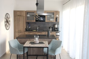 Una cocina moderna con armarios de madera, una isla central y una zona de comedor con dos sillas.