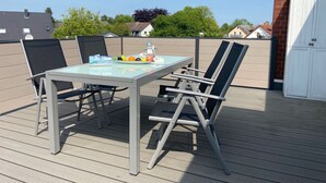 A rooftop terrace with a glass table, two chairs, and a fruit bowl. - 1805 - Ostseestern - 1805 - Ostseestern in Dahme (Dahme)