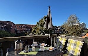 A wooden deck with a table set for breakfast, including a kettle, cups, and a plate of food. - 7008 - An der Aue 9a - 7008 - "Domicil" - An der Aue 9a - Apartment 19 (Dahme)