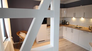 A modern kitchen with white cabinets, a wooden countertop, and a built-in stove.