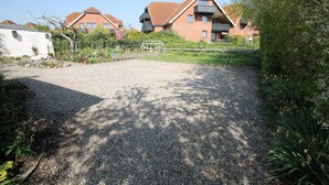 Un quartier résidentiel comprenant deux maisons en briques, une allée gravillonnée et de la verdure environnante.