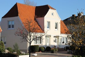 A two-story house with a red-tiled roof, white exterior walls, and a small front porch. - 5070 - Groote Lüü - 5070 - "Groote Lüü" - Saarstrasse 15 (Dahme)