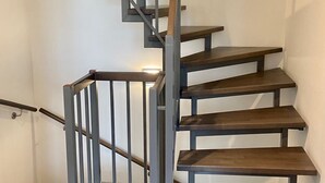 A spiral staircase with wooden steps and metal railings.