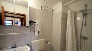 A modern bathroom with a sink, toilet, and shower.