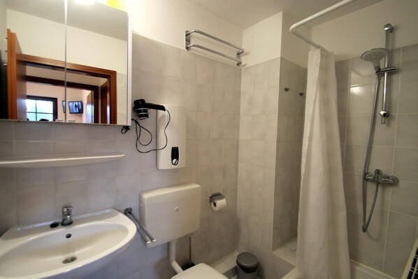 A modern bathroom with a sink, toilet, and shower.