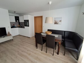 Un appartement moderne comprenant une cuisine, un coin repas et un salon.