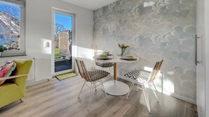 A dining area with a round table, two chairs, and a view through a glass door to the outside. - 1003 - Lütt Wulkjes - Lütt Wulkjes - Nordic charm (Dahme)