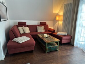 Una sala de estar con un sofá modular, una mesa de centro y una lámpara de pie.