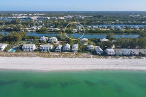 An aerial view of a coastal area with beachfront properties, a marina, and a large body of water. - Pool home on Bocilla Lagoon (Placida)