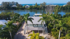 A beachfront property with a covered patio, a pool, and a view of the ocean. - Pool home on Bocilla Lagoon (Placida)