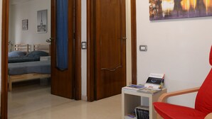 A room with a bed, a chair, a bookshelf, and a painting on the wall. - Emilio's Home Entire Apartament up to 7 people (Roma)
