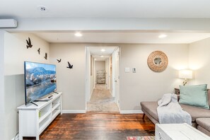 Relax in this inviting living space with a flat-screen TV, comfortable sofa, and cozy coffee table.
