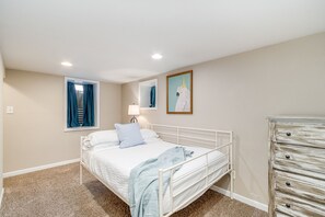 Cozy retreat with a comfortable bed, a dresser, and a window with a view.