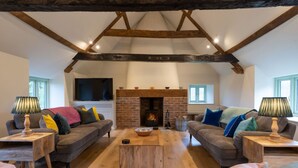 A cozy living room with two sofas, a fireplace, and a television. - Apple Loft -  Beautiful Somerset cottage, sleeps 13 guests  in 6 bedrooms (Ilminster)