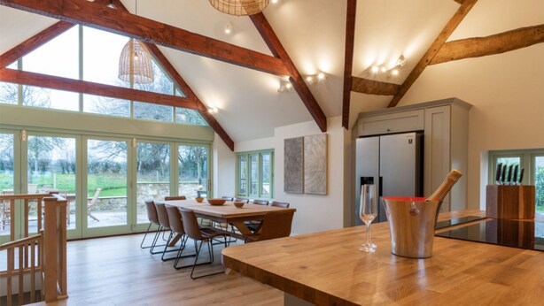 A spacious kitchen with a wooden dining table, a large window, and a view of the outdoors. - Apple Loft -  Beautiful Somerset cottage, sleeps 13 guests  in 6 bedrooms (Ilminster)