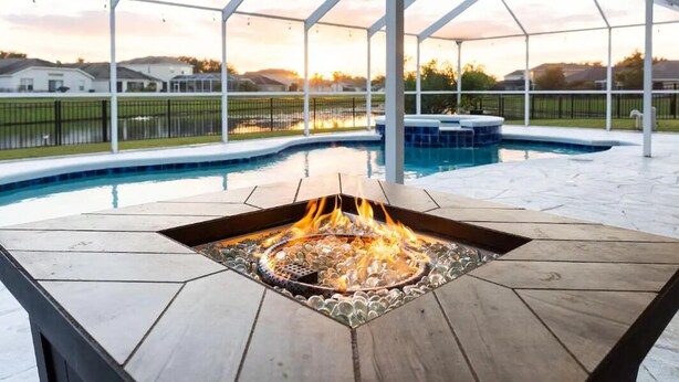 A pool area with a fire pit table, a hot tub, and a covered patio.