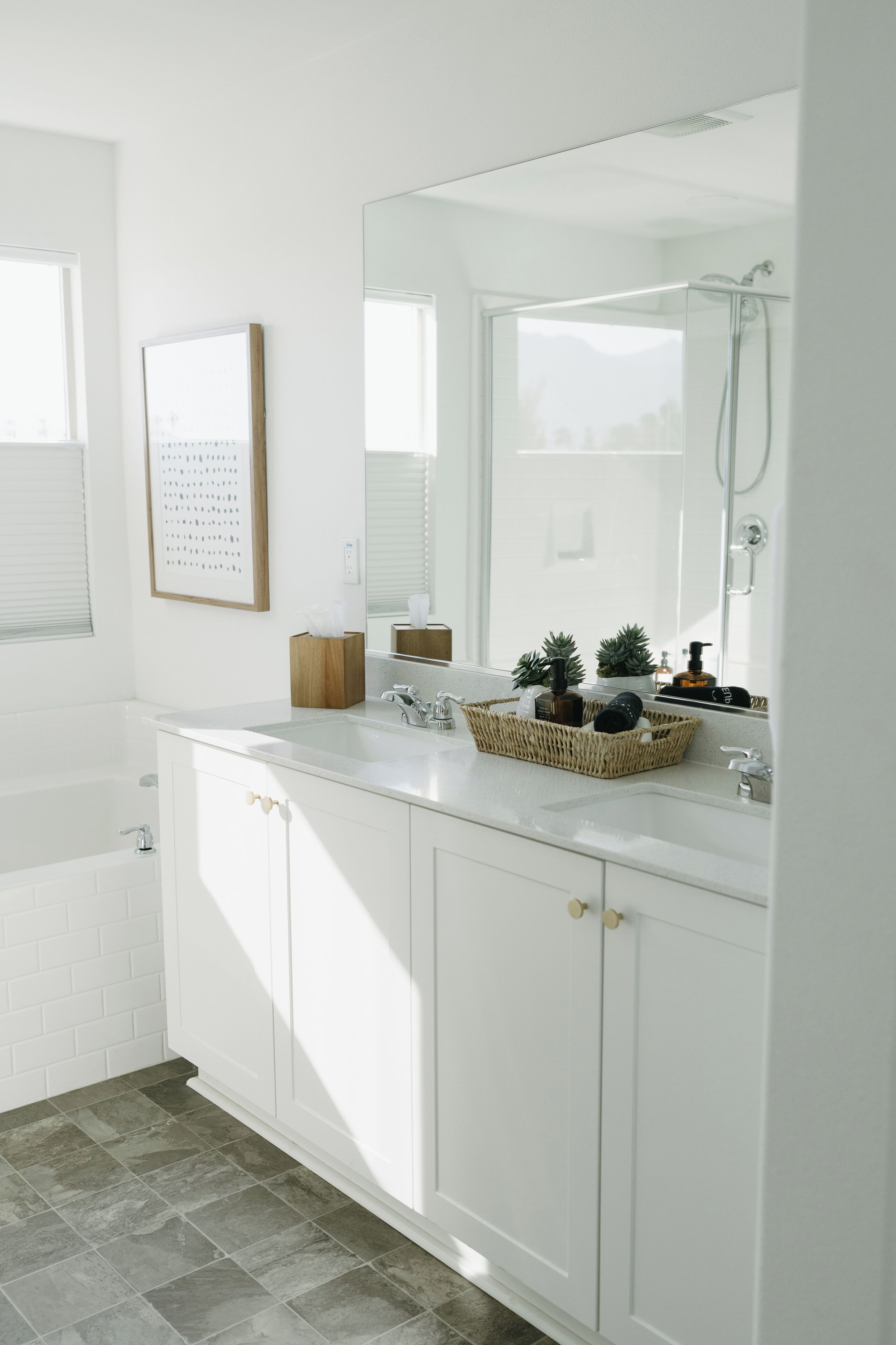A modern bathroom with a white vanity, a large mirror, and a shower.