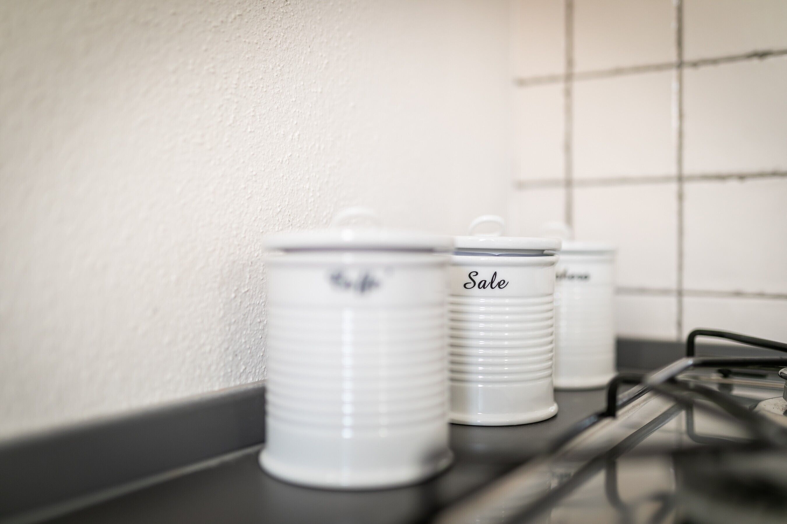 Recipientes blancos para guardar alimentos con tapas sobre una encimera.