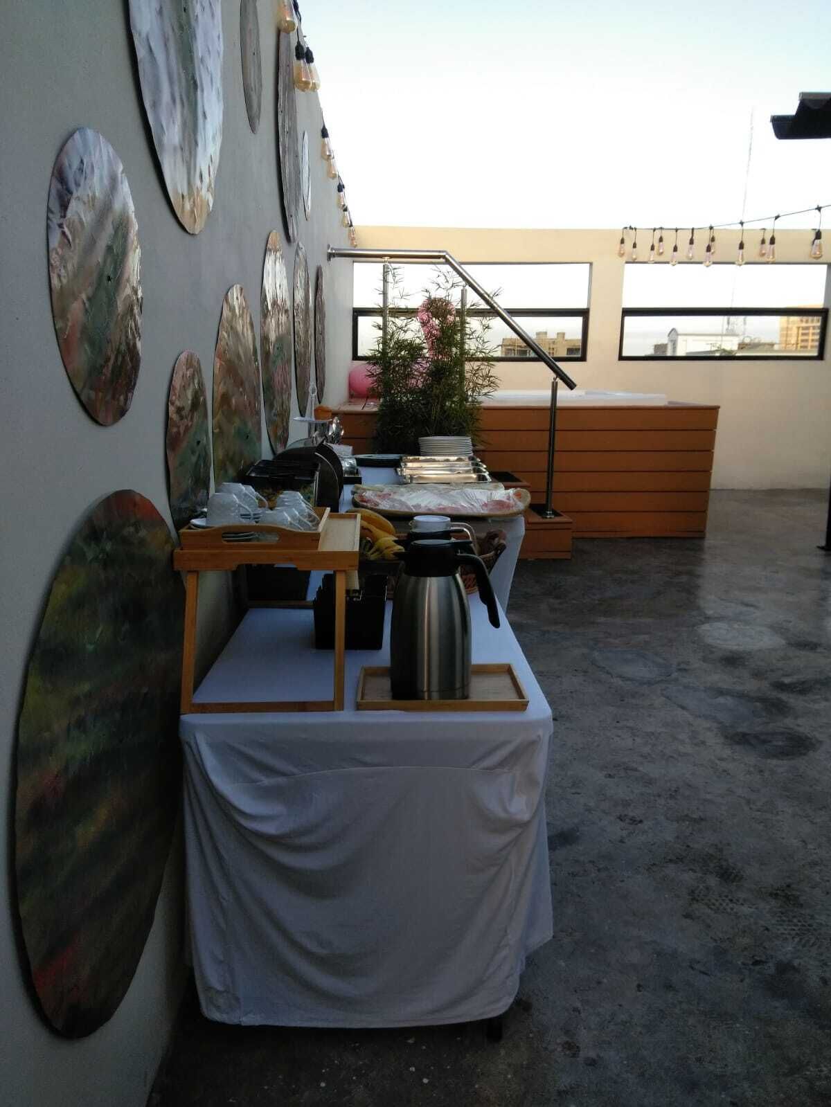Ein Dachterrasse-Essbereich mit gedecktem Tisch, umgeben von abstrakter Wandkunst.