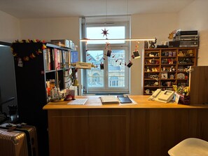 Un bureau à domicile équipé d’un bureau, d’étagères, d’une fenêtre décorée d’une étoile et offrant une vue sur le paysage urbain.