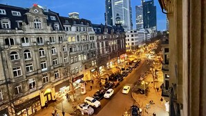 A city street at dusk with historic buildings and modern skyscrapers. - JC&BLUE Guesthouse - Hostel (Frankfurt)