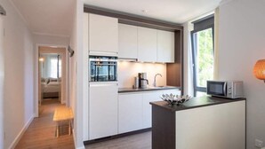 A modern kitchen with white cabinets, a built-in oven, and a microwave. - Villa Maxim, App. 2, Germany (Heringsdorf)