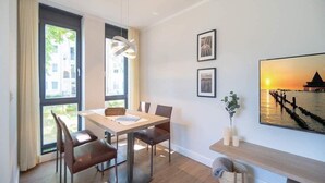 A modern dining area with a table, chairs, and a large window. - Villa Maxim, App. 2, Germany (Heringsdorf)