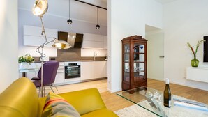Ein modernes Wohnzimmer mit einem gelben Sofa, einem Glastisch und einer Weinflasche.
