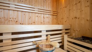 A wooden sauna with benches and a bucket with a wooden scoop. - Quartier 7, App. 07, Germany (Heringsdorf)