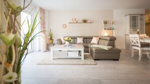 Un salon moderne avec un canapé, une table basse et des étagères.