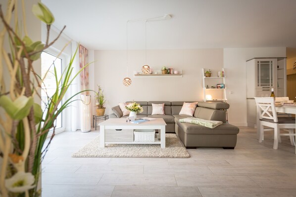 A modern living room with a sofa, coffee table, and shelves.