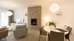 Uma sala de estar moderna com lareira, área de refeições e assentos.