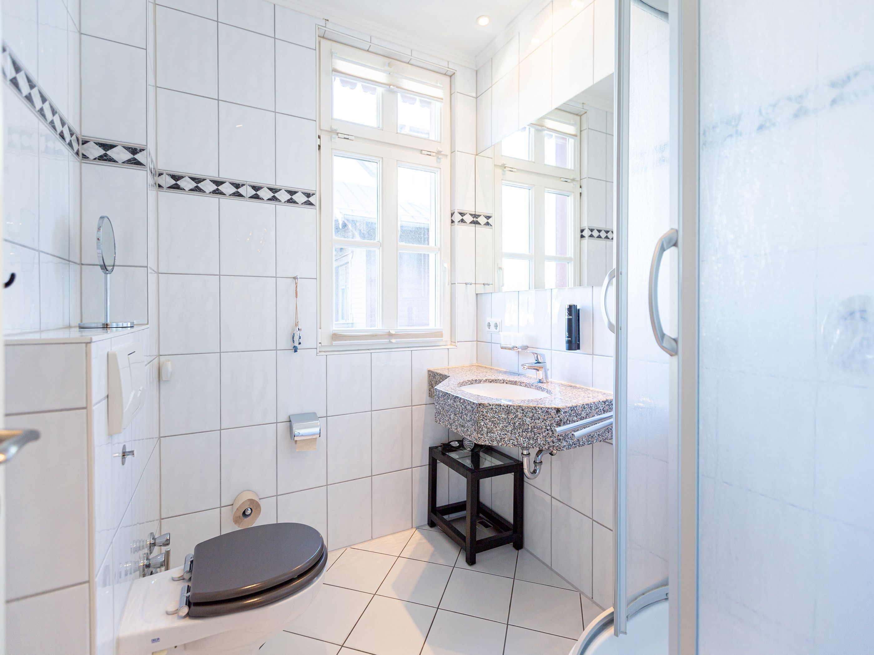 Une salle de bain moderne équipée de toilettes, d’un lavabo et d’une douche.